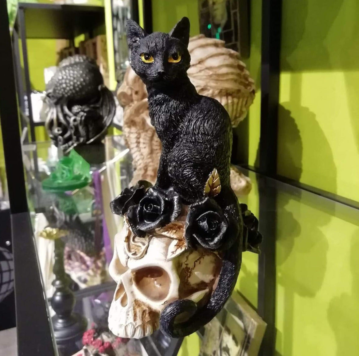 Gato negro, cráneo y rosas